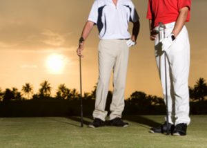 Two Men Standing in Golf Links, Holding Golf Clubs, Sunset Behind the Men